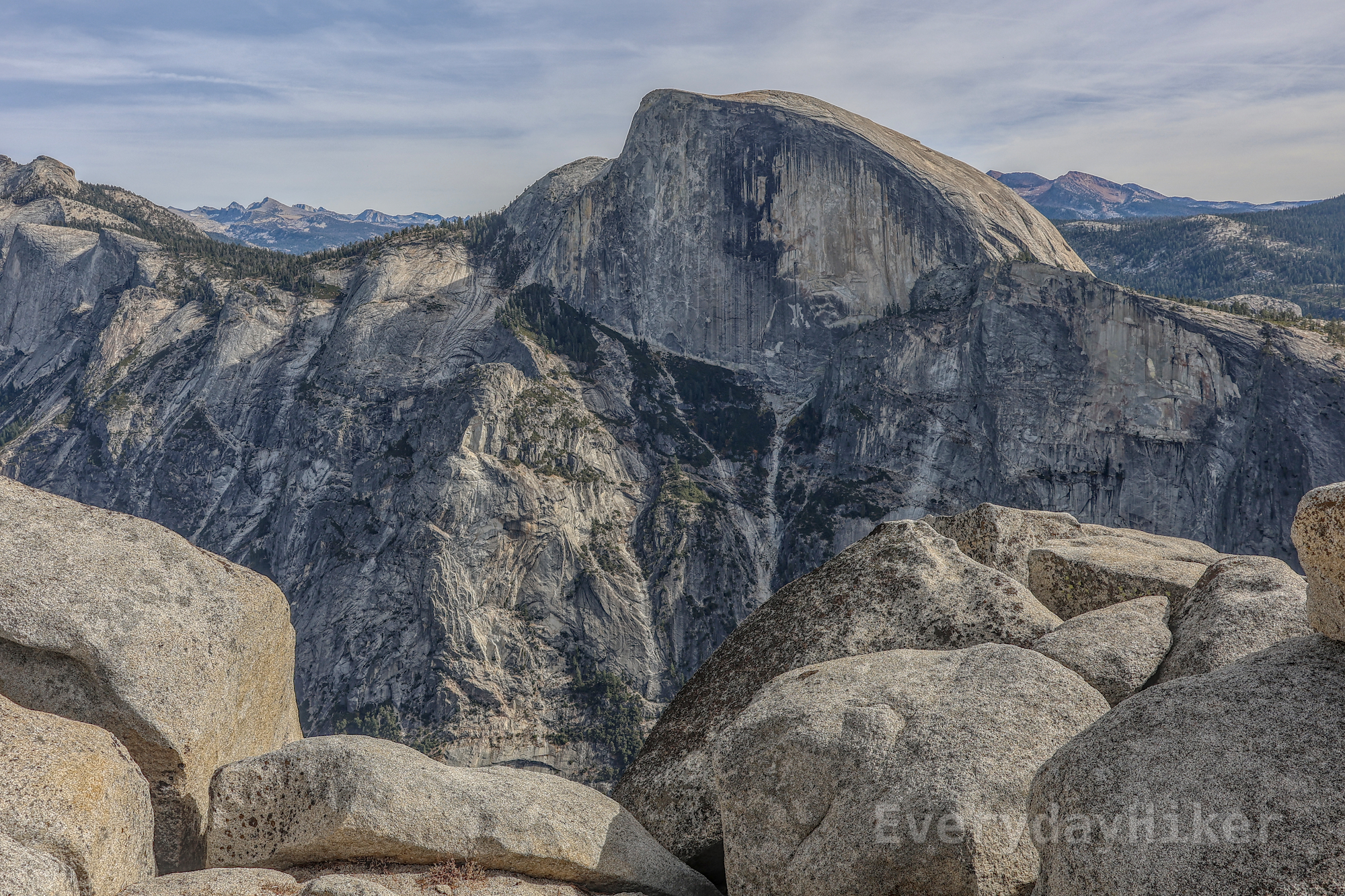 Looking across the valley towards Half Dome from North Dome, which frames the lower portion of the photo.  I believe that is the various peaks along Mt Ansel Adams in the distant left.
